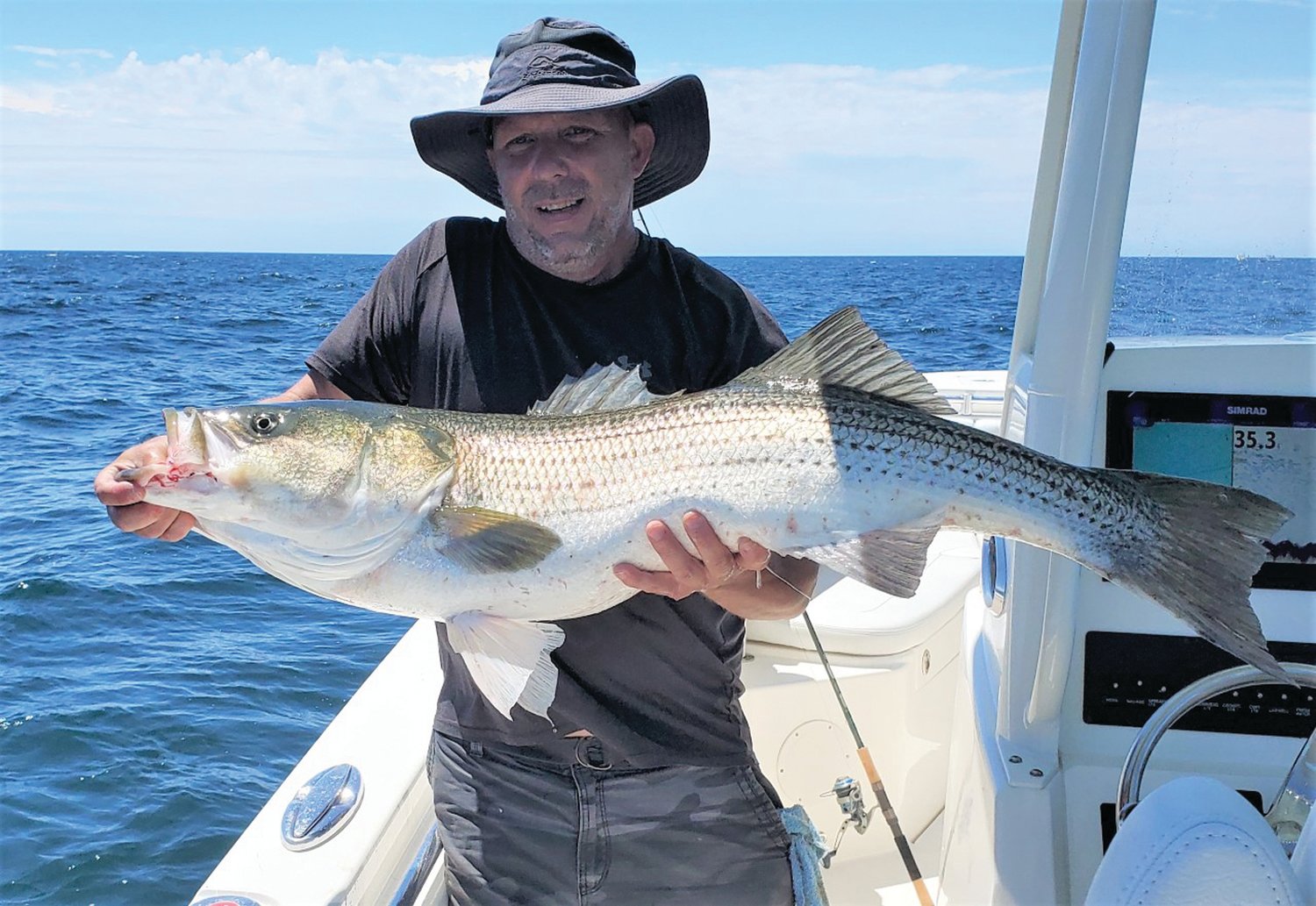 CATCH AND RELEASE: Tom Peters of Warwick with a striped bass he caught at Block Island’s Southwest Ledge when fishing with his brother Allan Peters (also of Warwick). (Submitted photos)